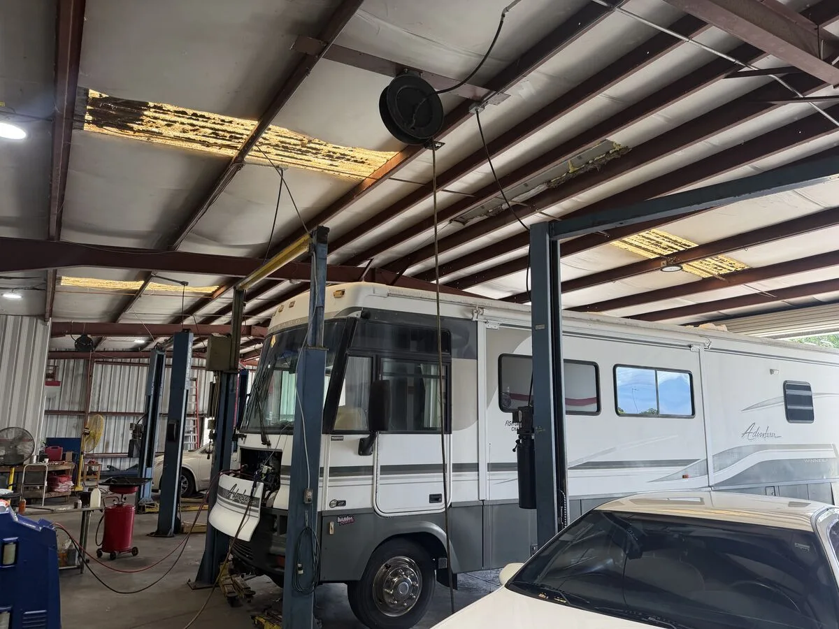 A 35-foot RV inside Mike's Expert Auto Repair with room to work around it